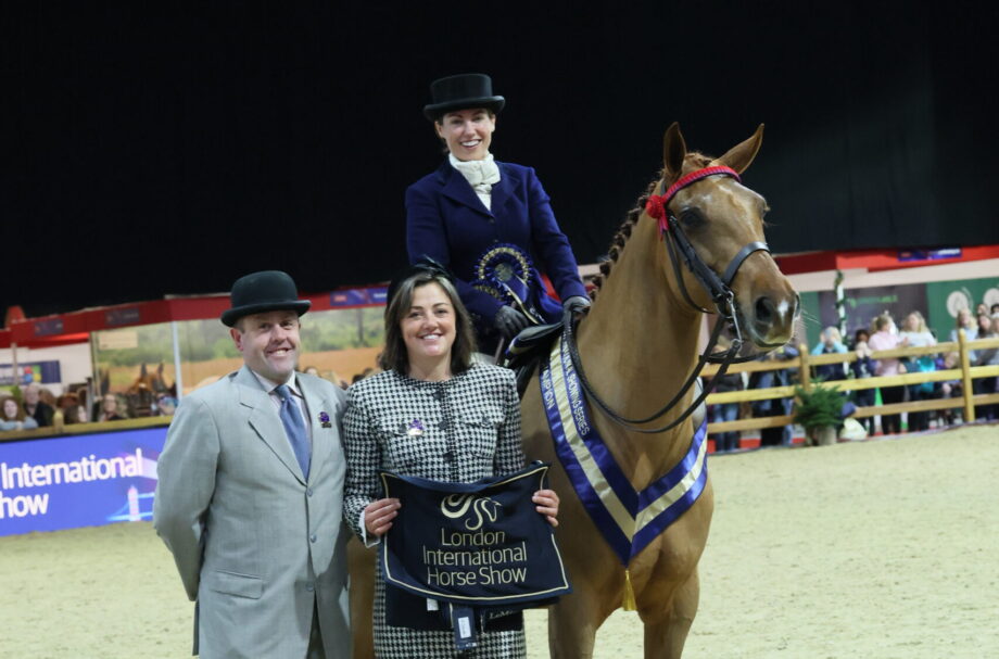 Rosa Cartwright and 2025 Rising Stars hack and riding horse champion Greenvale Don Legend stand for a photo with judges Mathew Ainsworth and Michaela Bowling at London International
