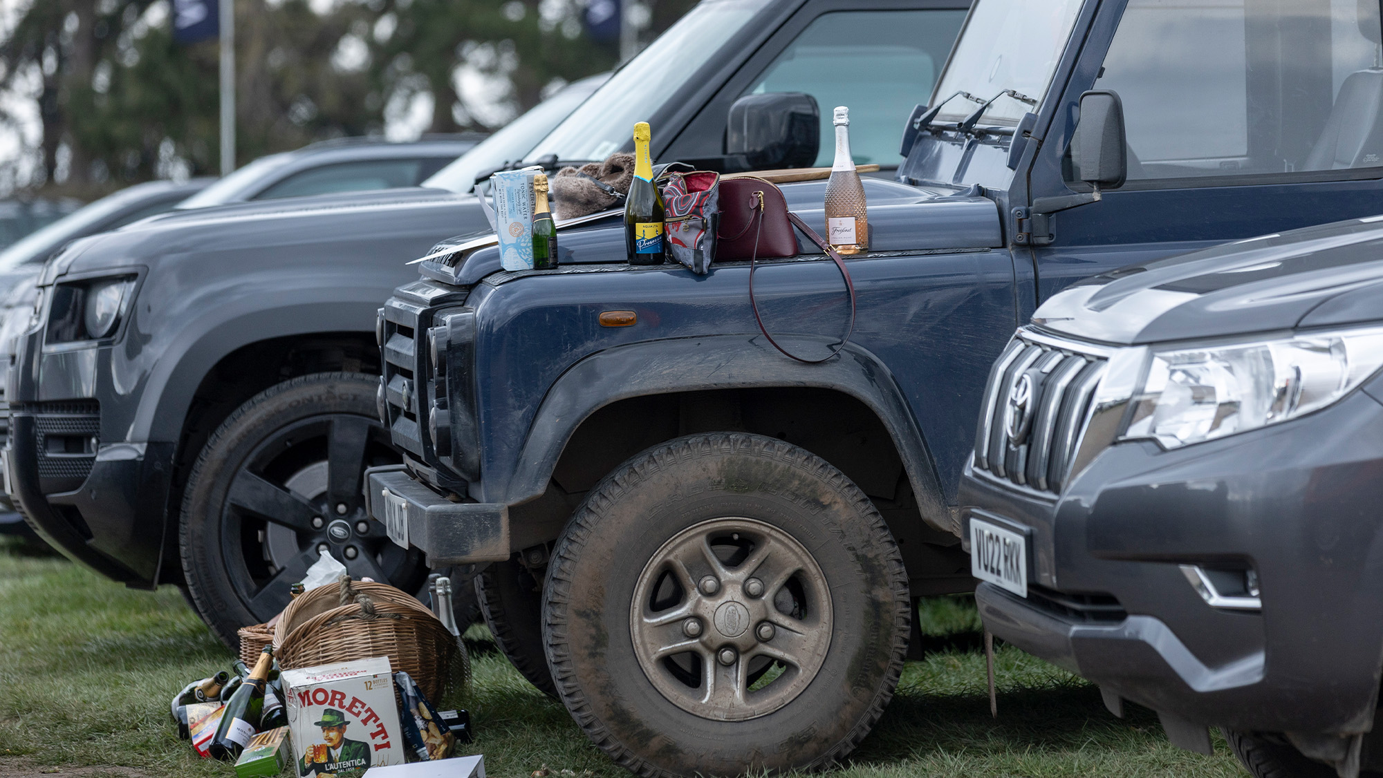 Cars parked in the Cheltenham racecourse car park with drinks and bags on the bonnet