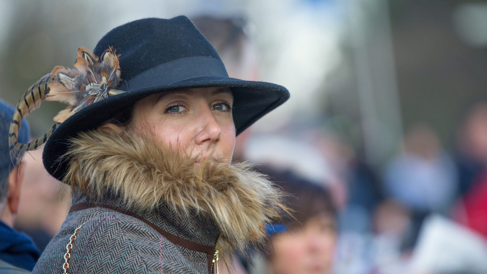 Lady dressed smartly with a fedora hat for Cheltenham races