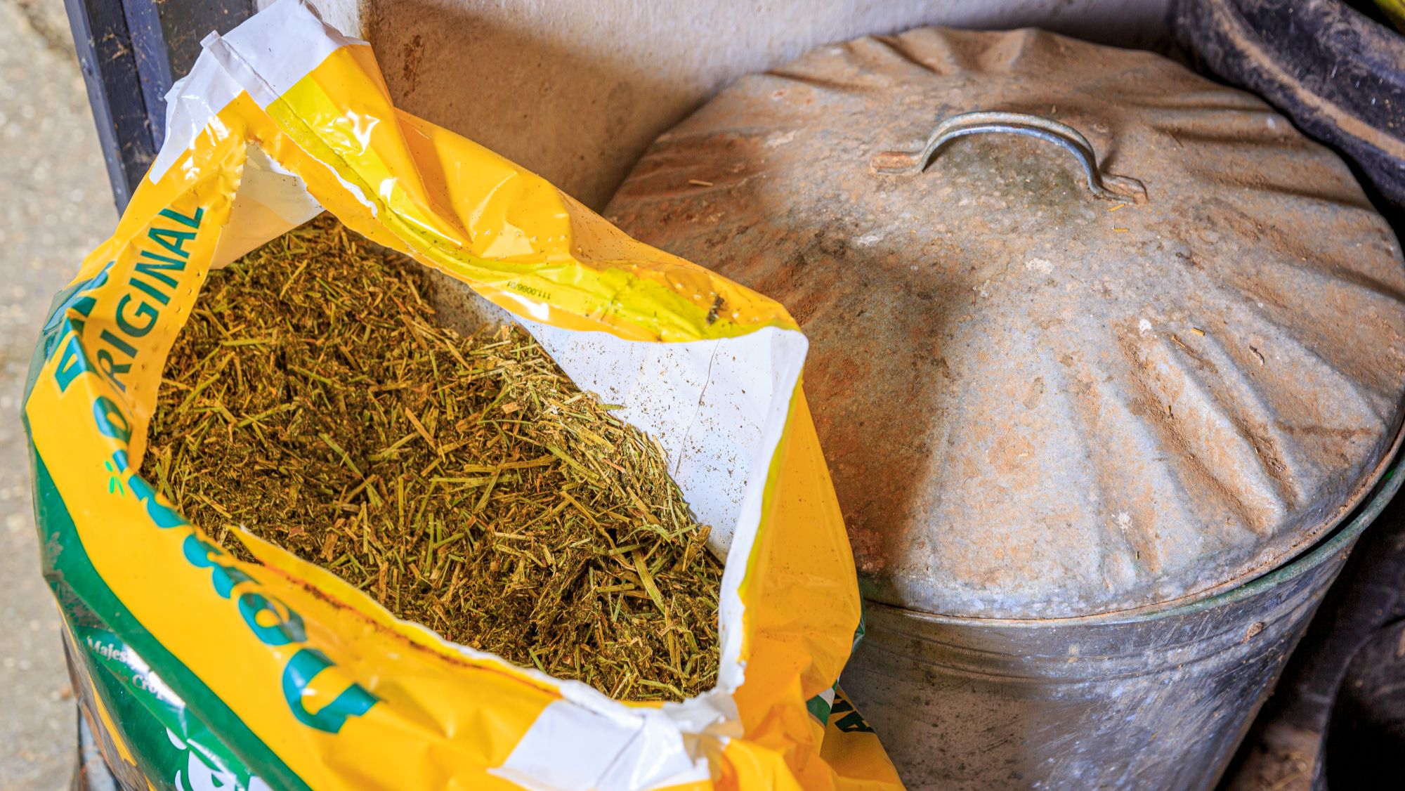 An open bag of chaff next to a metal bin
