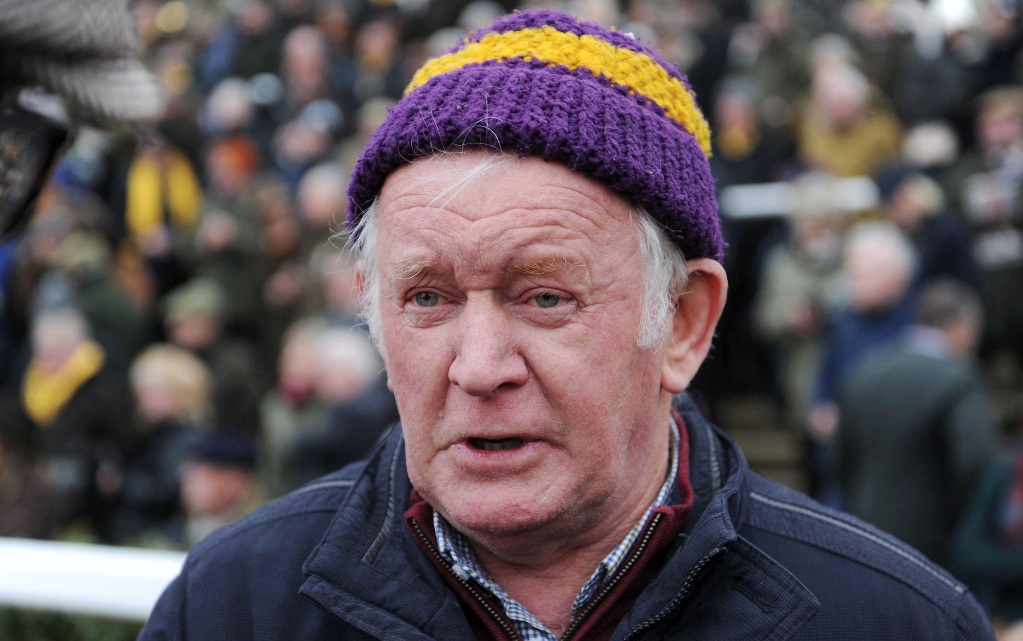 Jimmy Mangan,racehorse trainer, wearing purple and yellow hat