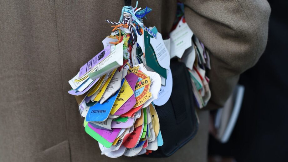 A racegoer carries ticket stubs attached to his bag from major racecourses as he arrives at Aintree Racecourse for the Grand National