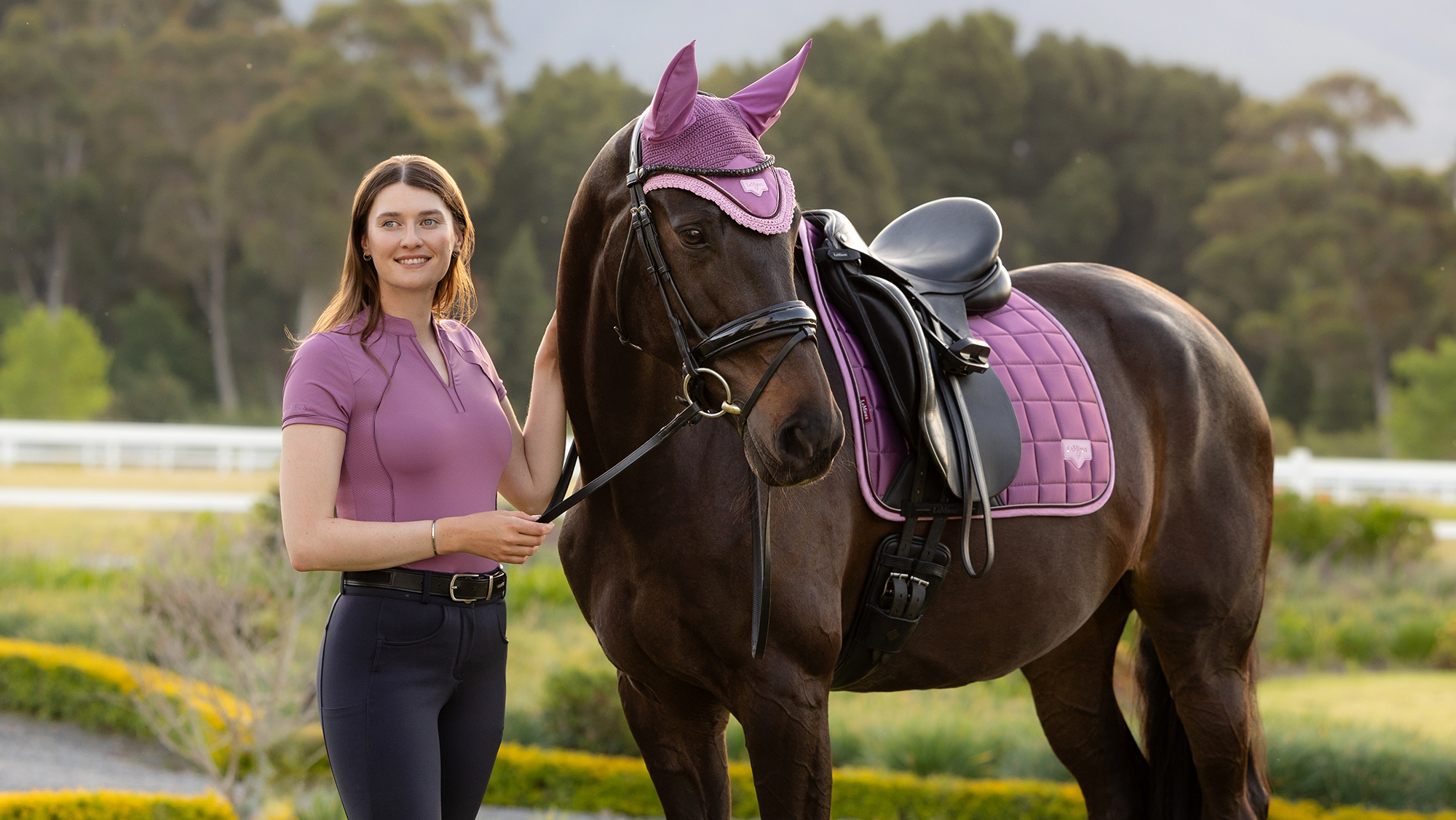 Lady standing by horse wearing new Lemieux SS26 mallow colour saddle pad and fly veil