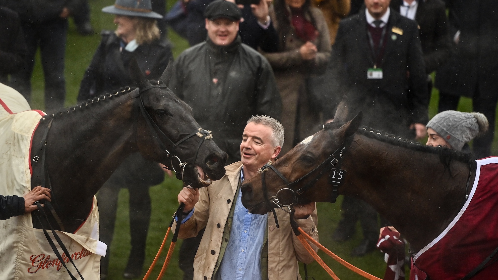 Michael O'Leary holding two horses at Cheltenham after finishing first and second in the cross-country chase