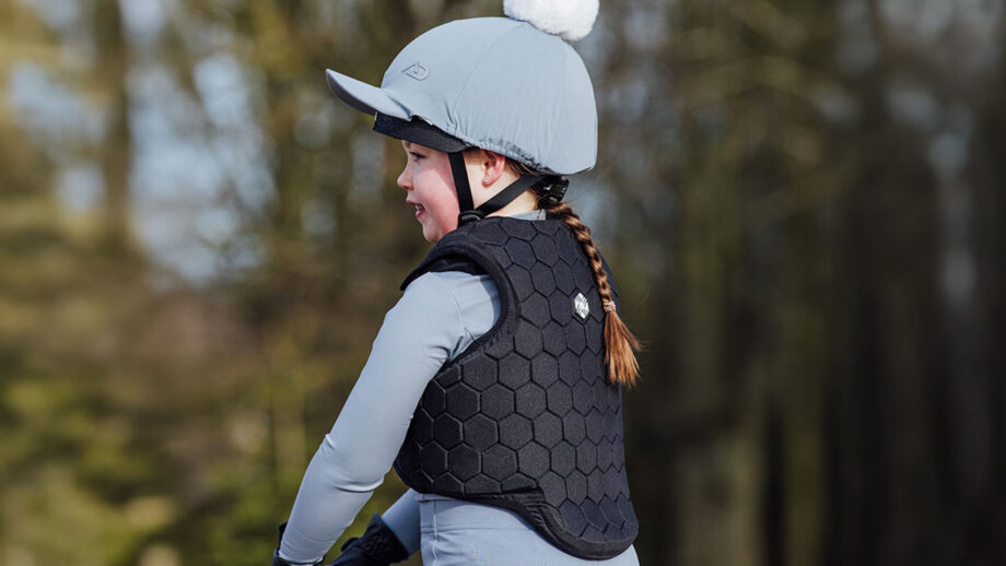 Child riding wearing Charles Owen EQx Hexa body protector close up of back view