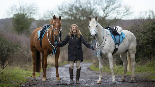 Endurance rider Emma Martin with her two horses, a chestnut and a grey