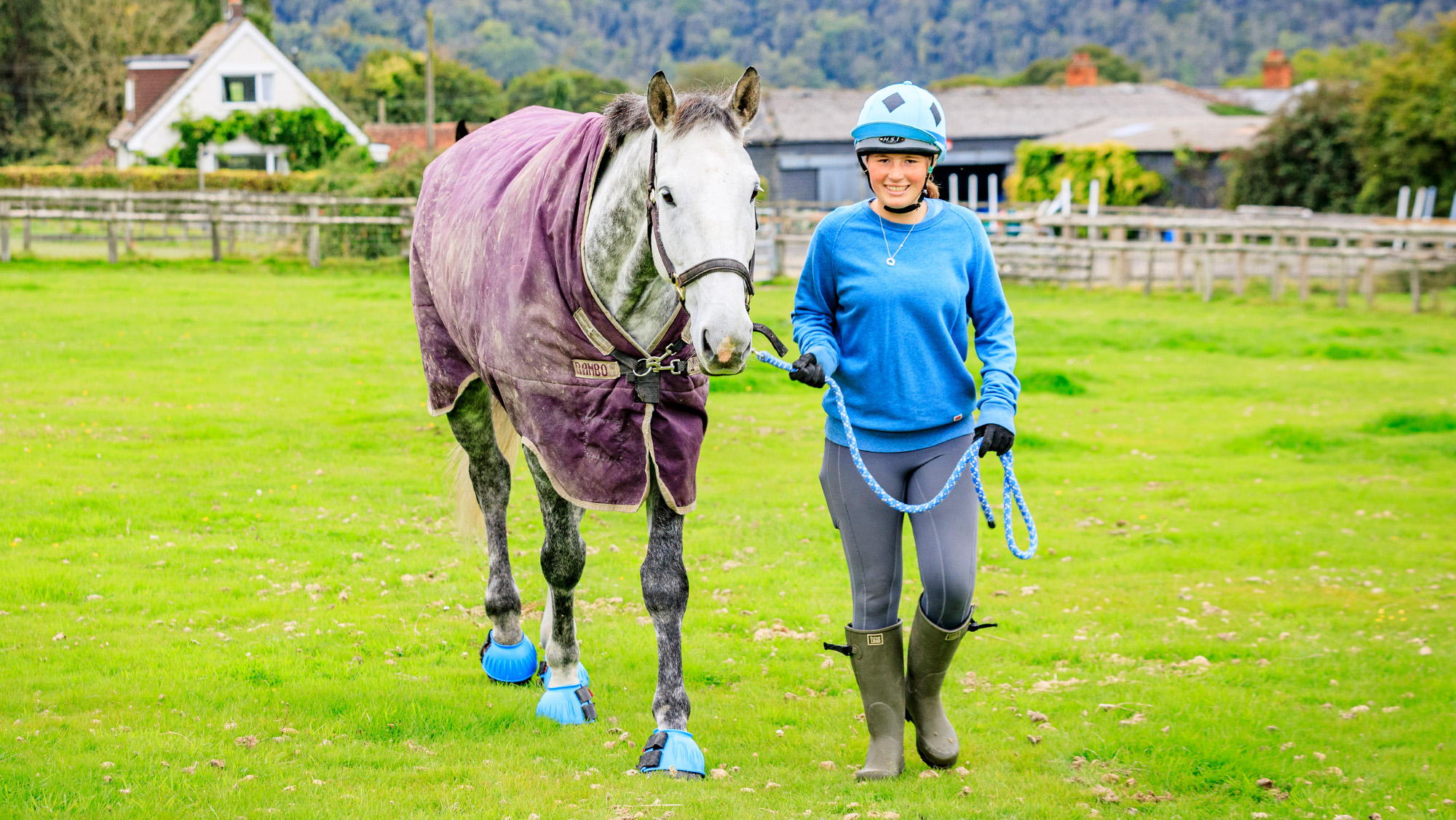 Female leading horse in a paddock