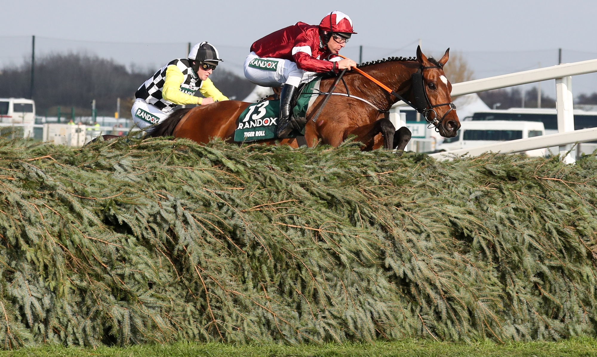 Tiger Roll over the Grand National fences, jockey Davy Russell with maroon and white silks.