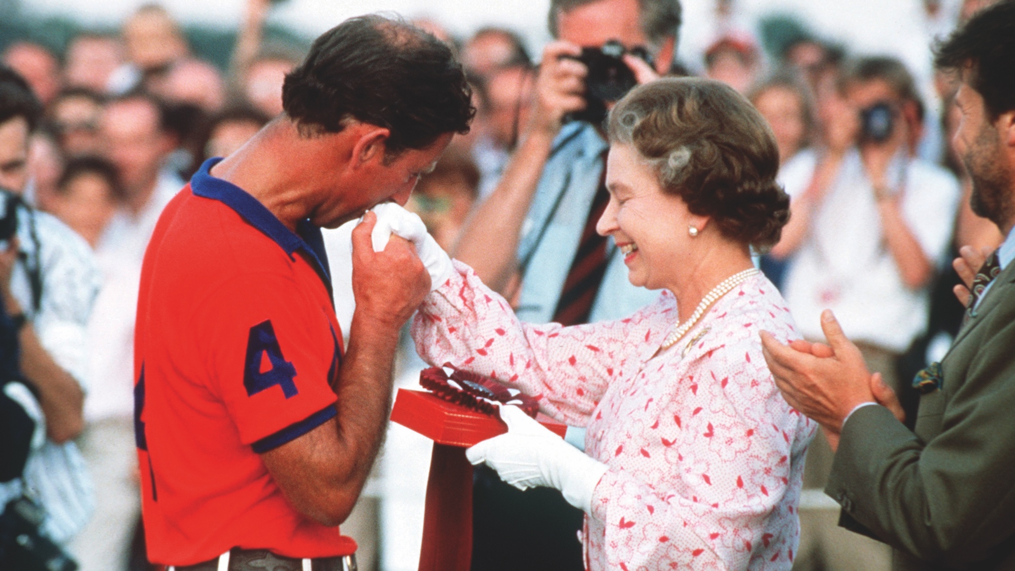 The Prince of Wales kisses the Queen's hand at Windsor Polo ground in 1986.