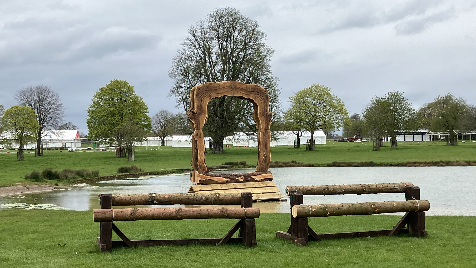 Two rustic rails sit kin the foreground with the lake behind. A five star owlhole fence is in the water.