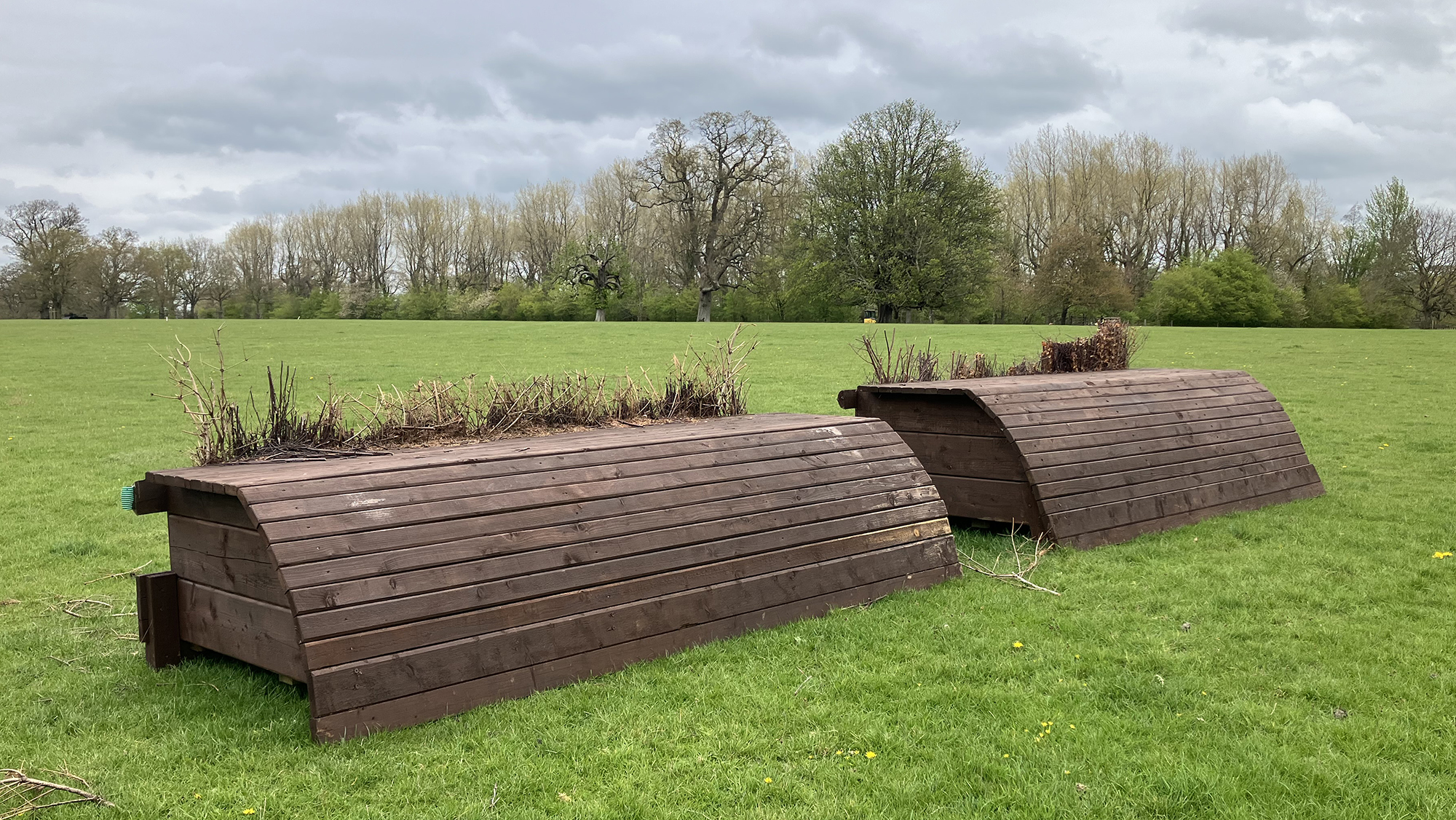 Two maximum height rolltop cross country fences with brush behind on the LeMieux Grassroots cross-country course