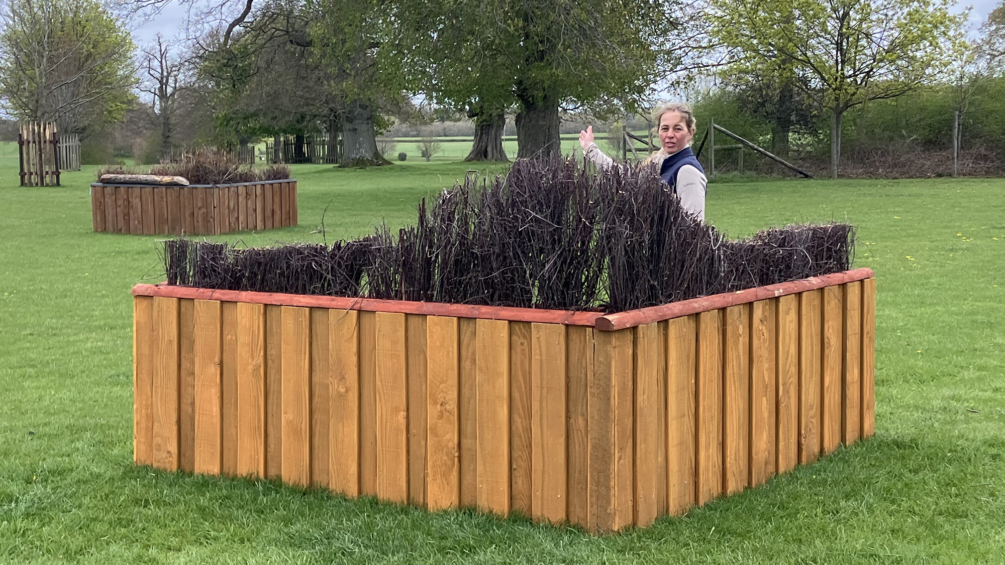 Kitty King stands behind the arrowhead brush using her arm to show the route.