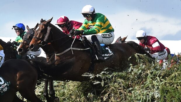 Jockey Paul Townend and I Am Maximus (C) jump The Chair on the way to winning the Grand National Handicap Chase on the final day of the Grand National Festival horse race meeting at Aintree Racecourse in Liverpool, north-west England on April 11, 2026. I Am Maximus became the first horse since Red Rum 49 years ago to regain his Grand National crown after he won a thrilling race at Aintree on Saturday. (Photo by PETER POWELL / AFP)