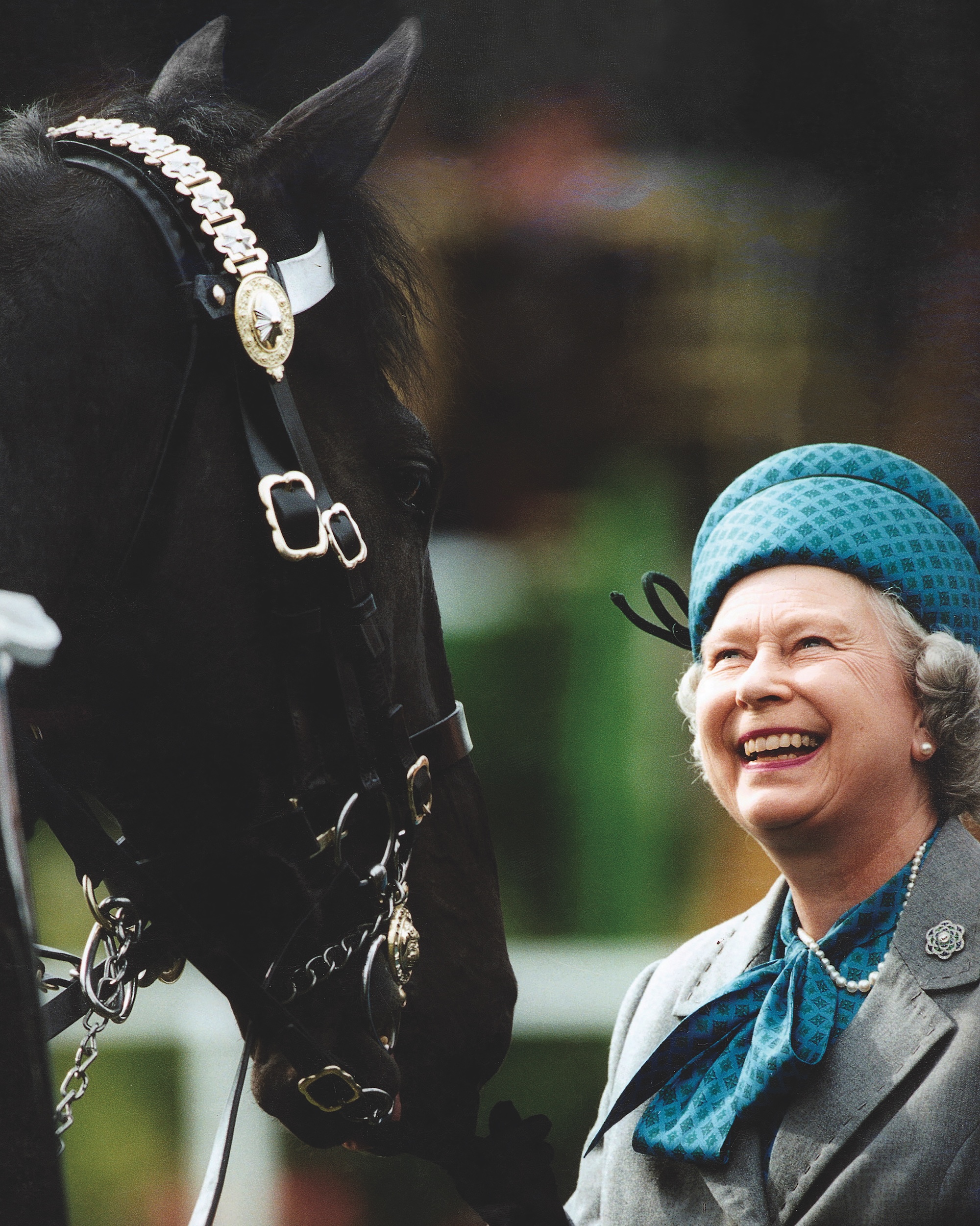 Queen Elizabeth II Smiling As She Reviews Troops Mounted On Horses At The Royal Windsor Horse Show.