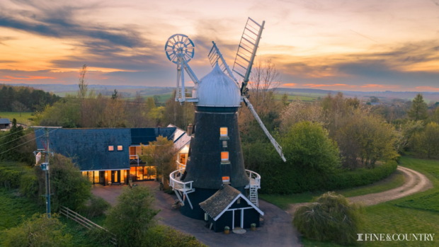 House and windmill with white sails at dusk