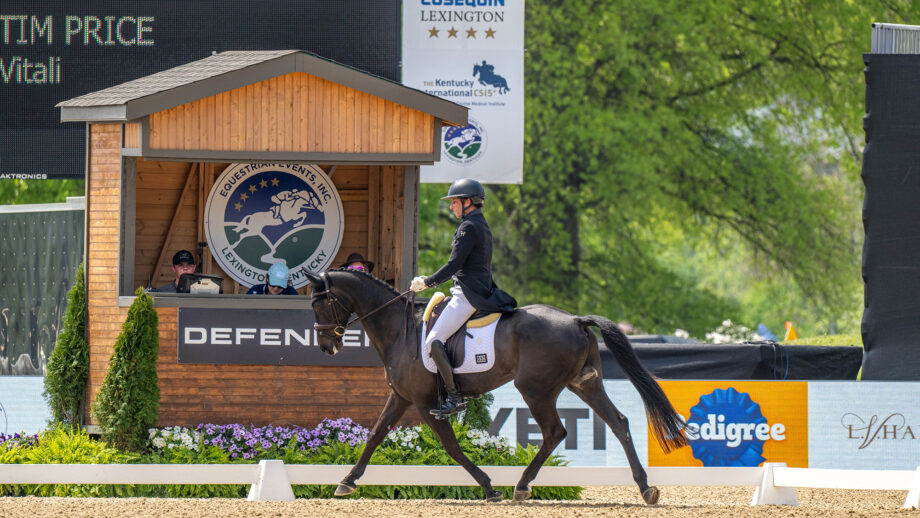 A dark event horse called Vitali ridden by Tim Price of New Zealand trots in front of a judges hut during the dressage phase of the five-star competition at Kentucky Three-Day Event 2026
