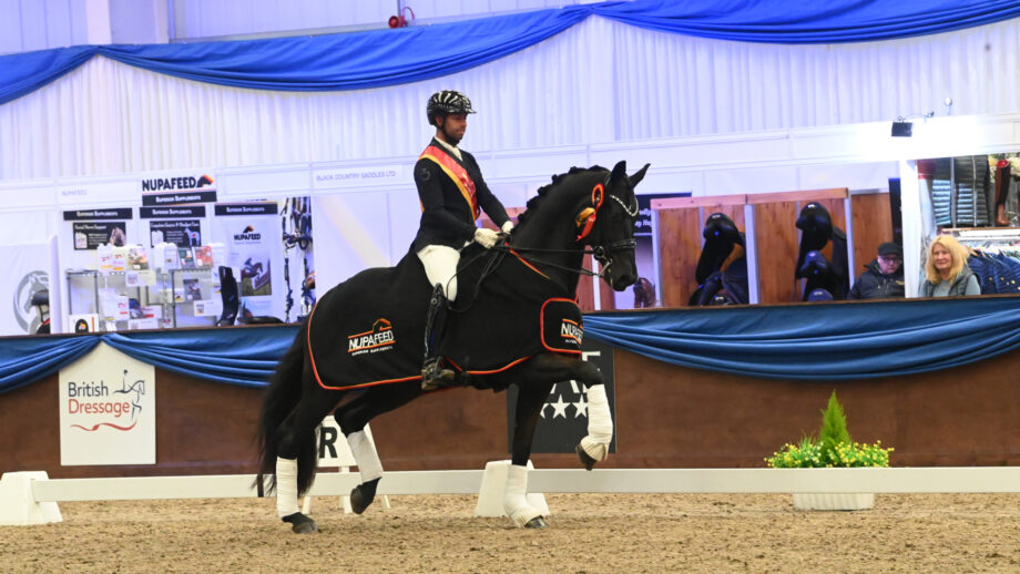 Dannie Morgan riding Belinski in the prizegiving wearing a sash and rug after winning the Nupafeed advanced medium freestyle gold at the Winter Dressage Championships.