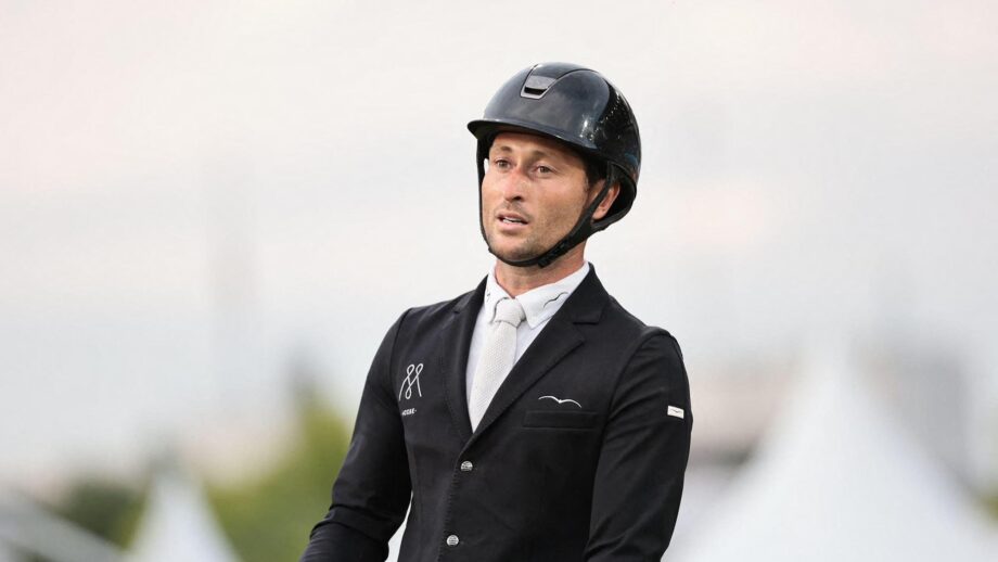 British showjumper Adrian Whiteway wearing a black show jacket and riding hat with a white shirt and tie.