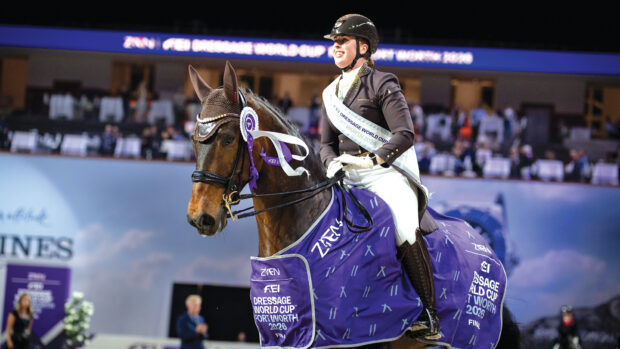 Female dressage rider Becky Moody wears her winners sash as she rides Jagerbomb, wearing his winner's rosette and rug on their lap of honour