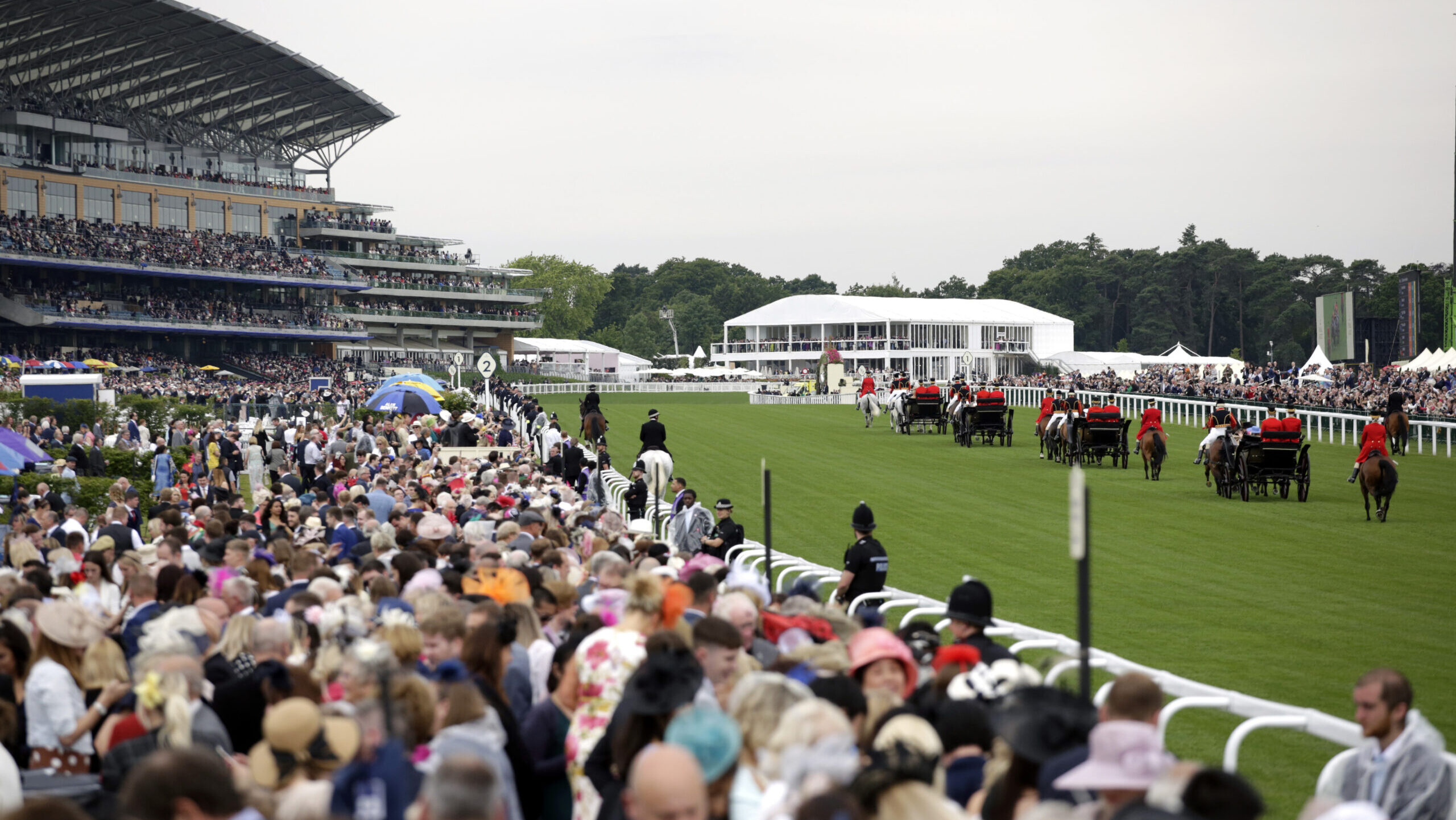 Racegoers watch the Royal Procession from the Windsor Enclosure at Royal Ascot