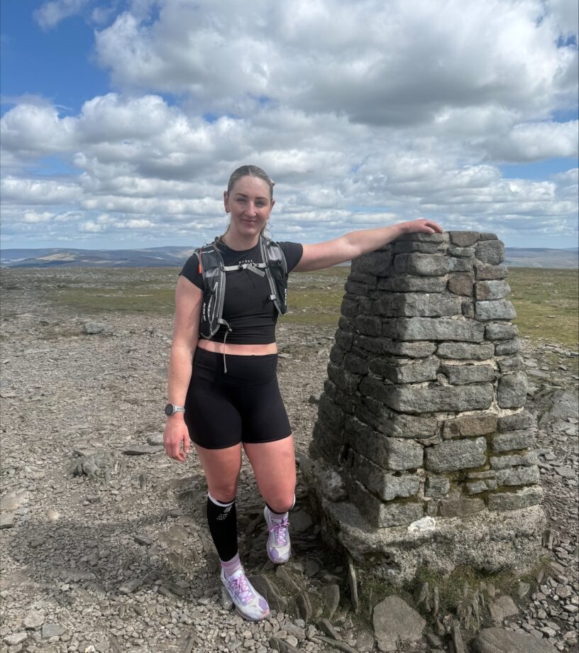 Natalie Dunning stands on a mountain peak