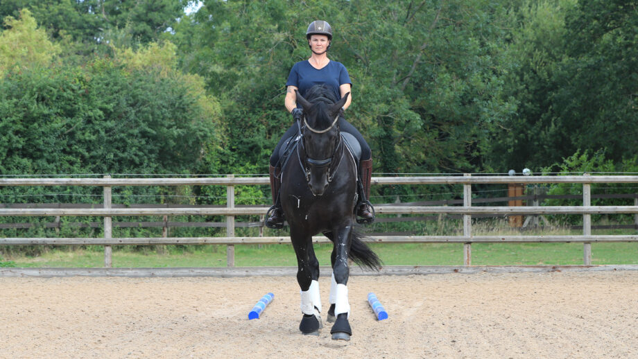 Tania demonstrating the polework exercise to improve centre lines, riding between the parallel poles