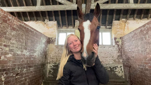 Meigs Rutherford, groom to Cassie Sanger, with Cassie's 2026 Badminton ride Redfield Fyre, in the stables at Badminton.