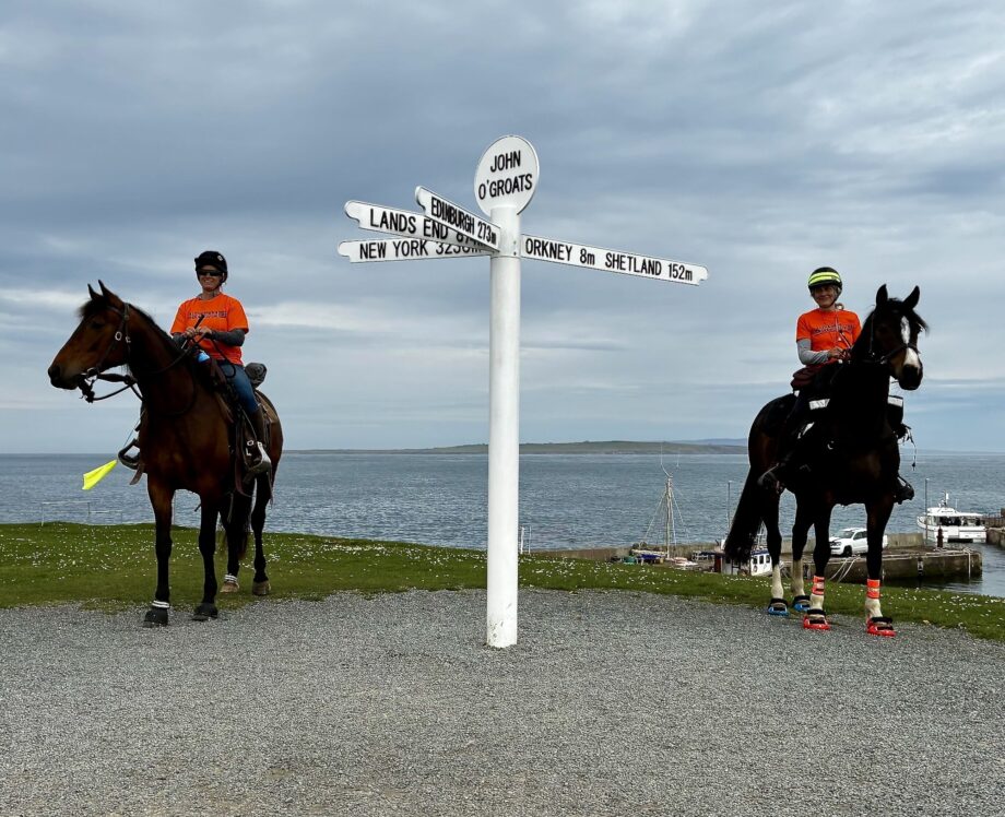 A rider and horse on each side of the John O'Groats sign