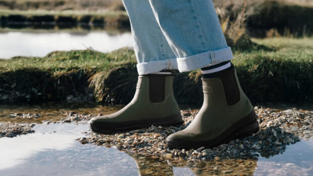 Lifestyle shot of Lemieux Bramshaw Chelsea Welly in Olive in a stoney puddle