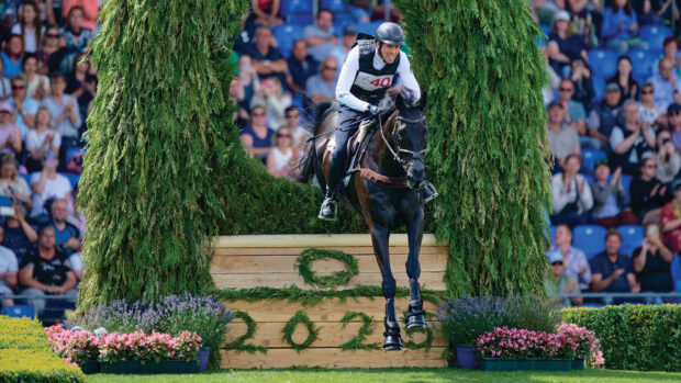 Jérôme Robiné and Black Ice jump a cross-country fence at Aachen 2025.