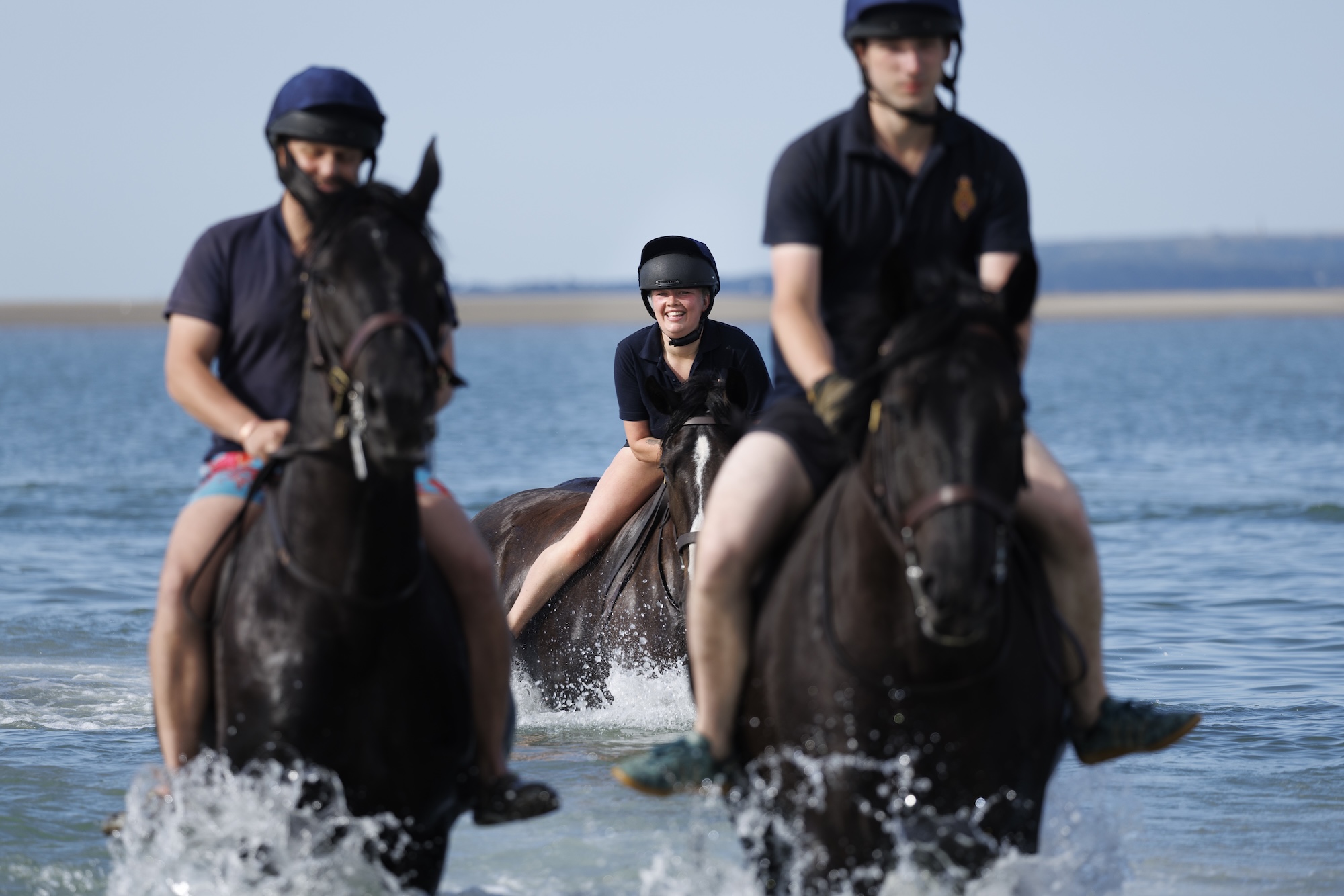 Pictured: Soldiers and horses from the Household Cavalry Mounted Regiment at Hayling Island beach on Friday 3 July 2026. The Household Cavalry Mounted Regiment swap the streets of London for the shores of Hampshire. As part of their three-week Summer Camp, The Life Guards and Blues and Royals deployed their Military Working Horses to Hayling Island Beach for a day of equine training with a difference. After welcoming four world leaders to Windsor, protecting The King at the State Opening of Parliament, and a spectacular King's Birthday Parade, a day in the sea felt very well-deserved. These horses face the noise and chaos of London every single day — sirens, crowds, and all the unexpected delights of city life, so building their confidence through exposure to new environments is essential. The beach — with its shifting sands, crashing waves, screeching gulls, and overexcited children — is the perfect testing ground. For the youngest horses, it was their very first encounter with the sea. Watching