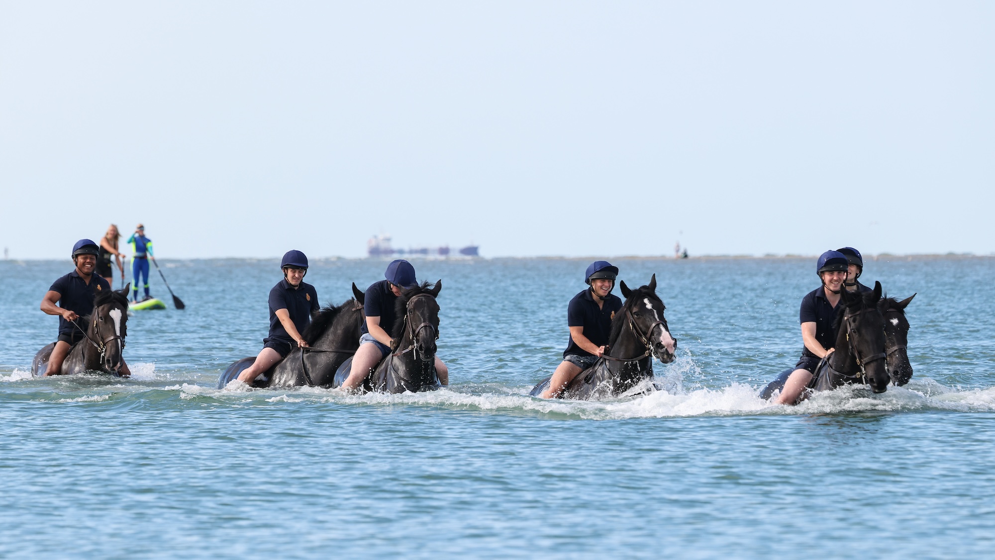 Pictured: Soldiers and horses from the Household Cavalry Mounted Regiment at Hayling Island beach on Friday 3 July 2026. The Household Cavalry Mounted Regiment swap the streets of London for the shores of Hampshire. As part of their three-week Summer Camp, The Life Guards and Blues and Royals deployed their Military Working Horses to Hayling Island Beach for a day of equine training with a difference. After welcoming four world leaders to Windsor, protecting The King at the State Opening of Parliament, and a spectacular King's Birthday Parade, a day in the sea felt very well-deserved. These horses face the noise and chaos of London every single day — sirens, crowds, and all the unexpected delights of city life, so building their confidence through exposure to new environments is essential. The beach — with its shifting sands, crashing waves, screeching gulls, and overexcited children — is the perfect testing ground. For the youngest horses, it was their very first encounter with the sea. Watching