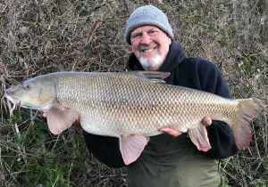 Pete Reading displays his 19 lb 11 oz Hampshire Avon barbel record.