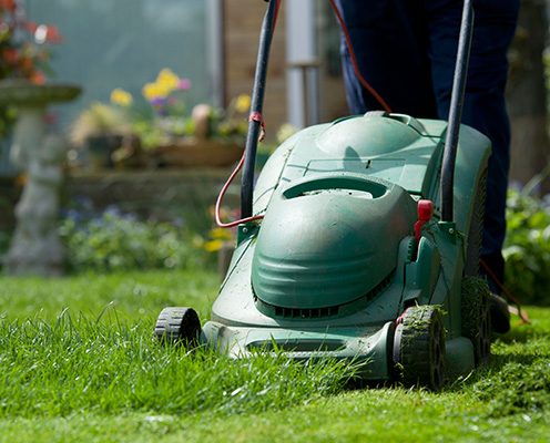 CP43B7 Gradener mowing the lawn in april. Cutting the grass. Gardening jobs