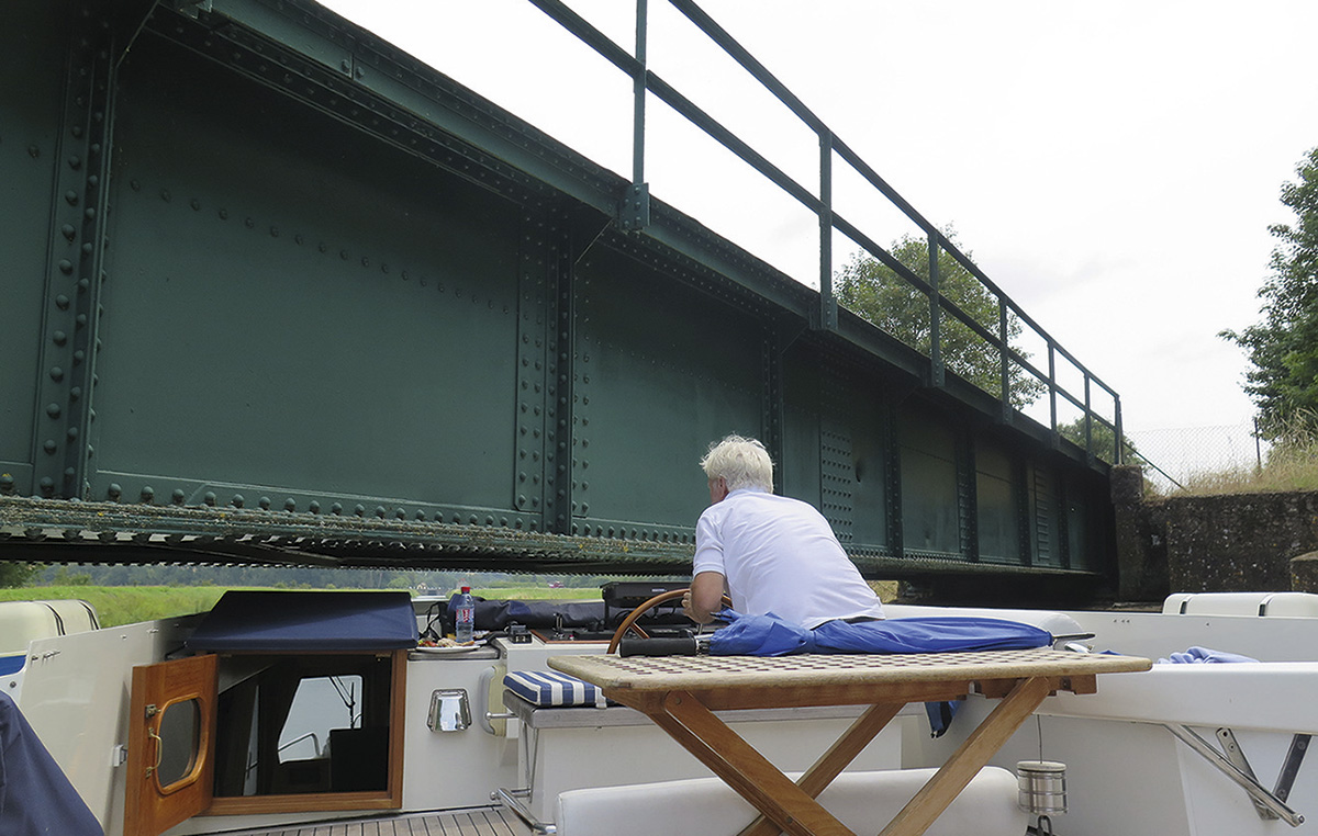 Howard Walker squeezes under a low bridge in the French canal system