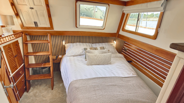 The finished aft cabin is much lighter and more comfortable, with room on both sides of the bed and a built-in television