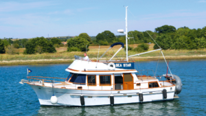 The renovated boat in the water with wooden trim
