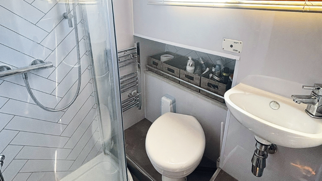 Stick-on vinyl tiling, a sliding timbre door for the shelf recess and some well chosen accessories result in a fresh, modern ensuite