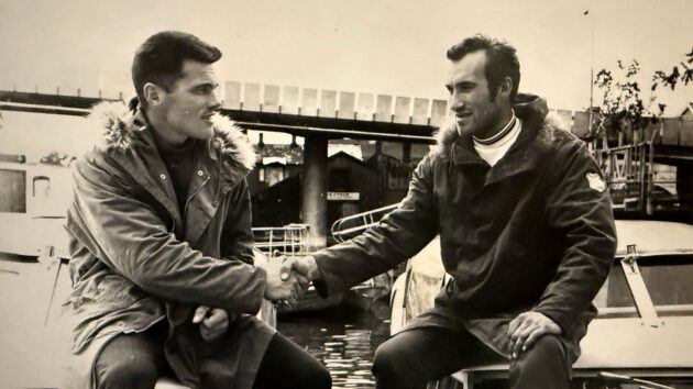 Two people shaking hands on boats