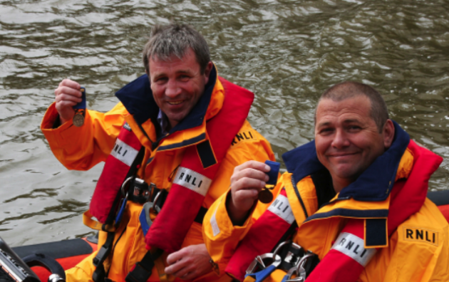 Anthony Chambers and Gary Fairbairn holding their RNLI Bronze Medals for Gallantry