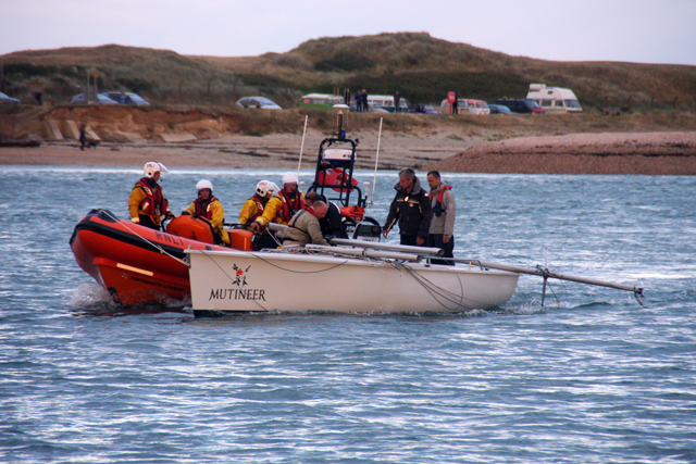 Dismasted sportsboat under tow. Credit: RNLI/Aaron Gent