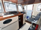 Tug Yacht 33 - The little ship theme continued in the raised pilot house with its pedestal captain's chair and vertical wheel