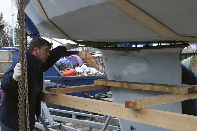 4: Using chains attached to strops Andy and his colleague Paul line the boat back up over the keel then carefully lower it down into place