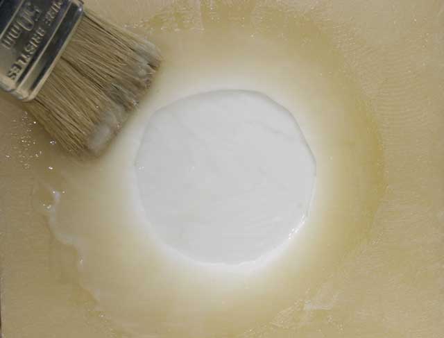 10: Mix up some thickened or pigmented epoxy (ordinary epoxy with some silica powder added) and paint it liberally onto the inside of the hole, so it covers all the depression and the faceplate. Brush carefully in order to avoid any air bubbles.