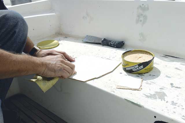 7: Lay up the repair against a blanking plate, which can be any slippery surface cut not much bigger than the size of the hole. We’re using a piece of white-coated hardboard. Three layers of release wax is rubbed onto the inside surface, avoiding lumps and smears.