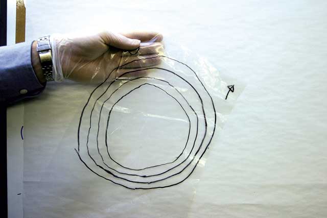 7: The building up of the hull is simply a re-run of the ‘ever-decreasing circles’ method. A polythene tracing sheet is laid over the depression, and a series of circles drawn on. These allow the sheets of cloth to be cut out, and then stuck down on the polythene. Once again, the smallest circle is stuck first, and the largest last. The sheet has to be marked for orientation.
