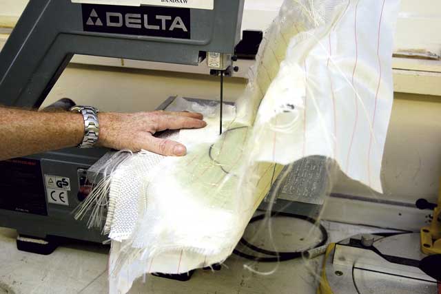 4: The mould is removed, the peel-ply pulled away, and the excess material removed with a band saw (you could use industrial scissors or a cutting disc).