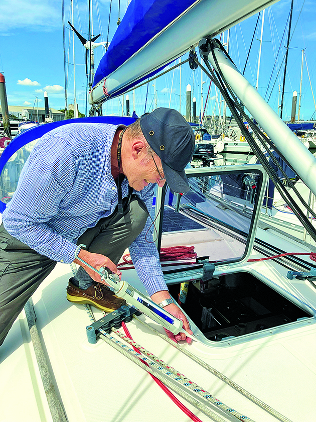 A man using sealant to fix a hatch on a boat to prevent boat leaks