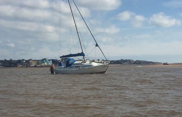 Exmouth RNLI crew member assists one of two stricken yachts in the Exe estuary. Credit: Exmouth RNLI