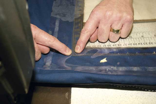 4: With the cover pulled up to the machine, still inside out, Alan identifies his target. He machines the outer seam first, running new stitching along the existing seam.